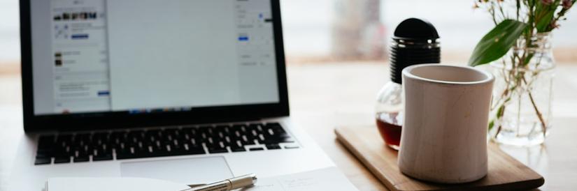 Photo of a laptop and coffee mug on a desk